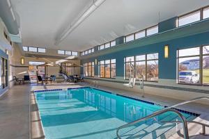 州学院贝斯特韦斯特大学公园套房酒店的一个带蓝色墙壁和窗户的大型游泳池