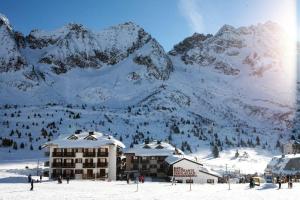 帕苏德尔托纳莱Apartment La Tonalina的雪覆盖的山前的滑雪小屋
