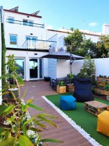 蓬塔德尔加达Santa Alegria Hostel的后院设有带遮阳伞和家具的庭院。