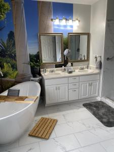 都柏林佩吉住宿加早餐旅馆的浴室配有2个盥洗盆、浴缸和浴缸。