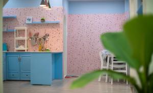 大叻Moc Thach Blue House DaLat的一间玩具厨房,内配蓝色橱柜和粉红色的墙壁
