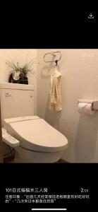 东京東洋の家-畳み部屋小庭園的浴室配有白色卫生间和毛巾。