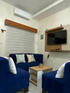 萨利纳斯Villa en Salinas vía Punta Carnero的客厅配有2张蓝色沙发和电视