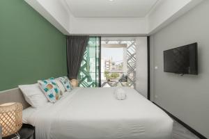 普吉镇Yanud Residence的卧室设有一张白色大床和一扇窗户。