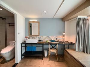 台北小公馆人文旅舍的浴室配有带水槽和卫生间的书桌。