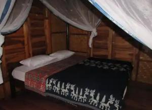 NdanguGUEST HOUSE的木制客房内的一间卧室,配有一张床