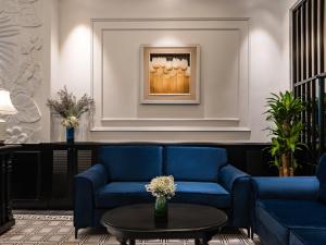 河内The Flower Boutique Hotel & Travel的客厅配有蓝色的沙发和桌子