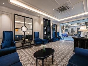 河内The Flower Boutique Hotel & Travel的客厅配有蓝色的椅子和桌子
