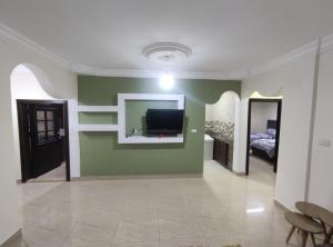 瓦迪穆萨noor apartment的客厅设有绿色墙壁上的电视
