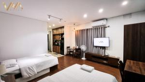 河内VNAHOMES Serviced Apartment的酒店客房设有两张床和一台平面电视。