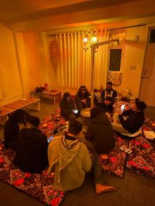 马拉里La Heim Hostels的一群人坐在客厅的地板上