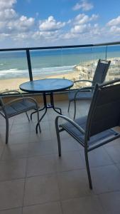 亚实基伦Blue Sea Suite的海滩阳台的桌椅