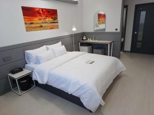 平泽市Hi& Hotel的卧室配有一张白色的大床和一张桌子