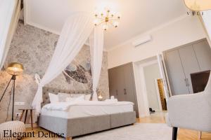奥拉迪亚Vili Apartments的卧室配有白色床和吊灯
