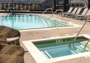 洛杉矶Apart Hotel near Dodgers Stadium的一个带椅子和桌子的大型游泳池