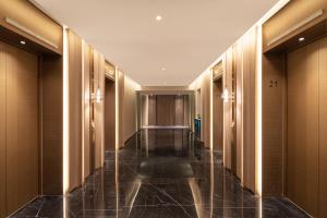 上海上海大华长风华邑酒店的酒店拥有木墙的酒店走廊和酒店客房的长走廊