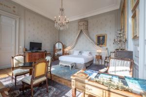 布尔日L'Hotel de Panette, Un exceptionnel château en ville的卧室配有一张床和一张桌子及椅子