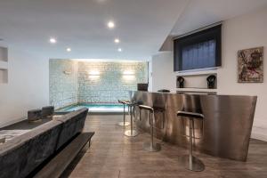 米兰Design Apartment with private pool exclusive use - Stelvio 21的一间带游泳池的客厅和一间带凳子的酒吧