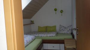 SandbergFerienwohnung Holzheimer的小房间设有一张带绿色枕头的床