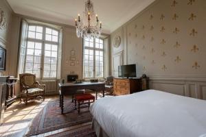 布尔日L'Hotel de Panette, Un exceptionnel château en ville的一间卧室配有一张床、一张书桌和一个吊灯。