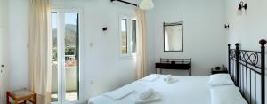 普拉提伊亚洛斯西弗诺斯LEANDROS APARTMENTS的白色的卧室设有床和窗户