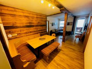 翁肯Natursport Heutal Appartements的用餐室设有木墙、桌子和长凳