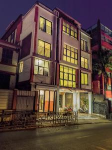 塔那那利佛Valiha Serviced Apartments Antananarivo的一座建筑,有许多窗户,前面停有一辆摩托车