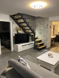 佩罗杰Apartment MM22的一间带电视和楼梯的客厅