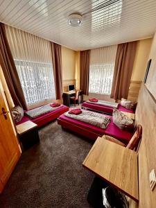 柏林Hotel Pension Pamina的酒店客房设有三张床和一张桌子