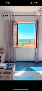 库斯托纳奇Villa “La Giummarra” - Scivolo di Cornino的客房设有海景大窗户。