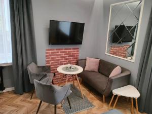 琴斯托霍瓦Apartament LUCY - ścisłe centrum Częstochowy的客厅配有沙发、椅子和电视