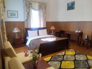 努沃勒埃利耶特列文酒店的一间卧室配有一张床、一张沙发和一个窗口