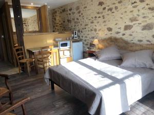 拉卡佩勒-马里瓦勒Maison d'hôtes " Ecuries de St maurice"的一间卧室配有一张床,厨房配有桌子