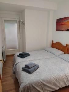 圭哈尔谢拉Apartamento Guejar Sierra的卧室内的两张床,配有两条毛巾