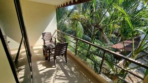 帕罗林帕罗林酒店的阳台配有两把椅子,享有棕榈树的景致。