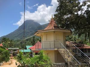拉特纳普勒Palabaddala Tea and Eco Lodge的一座小建筑,在山前有楼梯