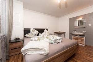 乌姆豪森Apart Ronja的一间卧室配有带枕头和水槽的床
