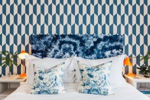 法尔茅斯Highcliffe的一间卧室配有一张带蓝色和白色枕头的床