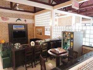 因比图巴野海滩酒店的餐厅设有酒吧、桌椅和游戏机