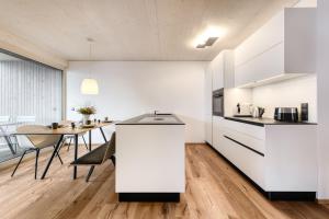 布兰德Appartement Zentral mit Panoramasauna by A-Appartments的厨房配有白色橱柜和餐桌