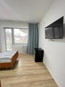 奇姆肯特TOURIST HOTEL的一间卧室配有一张床和一台平面电视