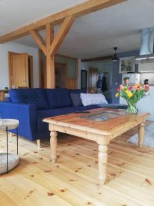 施托尔佩奥夫乌塞多姆NEU Ferienwohnung an der Landbäckerei的客厅配有蓝色的沙发和木桌