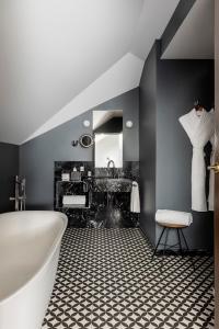 马德里TÓTEM Madrid, a Small Luxury Hotel of the World的浴室配有白色浴缸和水槽