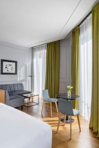 马德里TÓTEM Madrid, a Small Luxury Hotel of the World的酒店客房带一张床、一张桌子和椅子