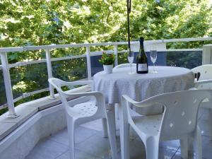 萨洛APARTBEACH SALOU y PLAYA 742的白色的桌椅和一瓶葡萄酒