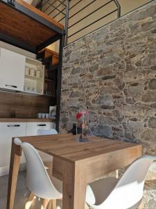 塞斯特雷Home holidays- attico arc en ciel的厨房配有木桌和椅子,设有石墙