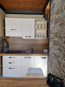 塞斯特雷Home holidays- attico arc en ciel的厨房配有白色橱柜和石墙