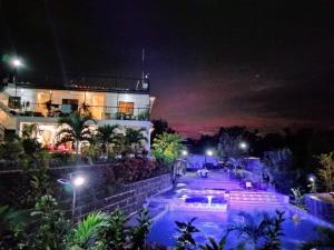 塔奈Casa de Robles Tanay Rizal的一座晚上有游泳池的建筑
