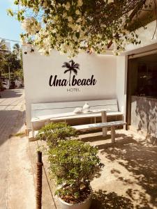 乌纳瓦图纳Una Beach Hotel & OLU Cafe的坐在建筑物边的长凳