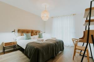 洛格罗尼奥Natural Stay Apartamentos PassivHaus的白色卧室,配有带毛巾的床